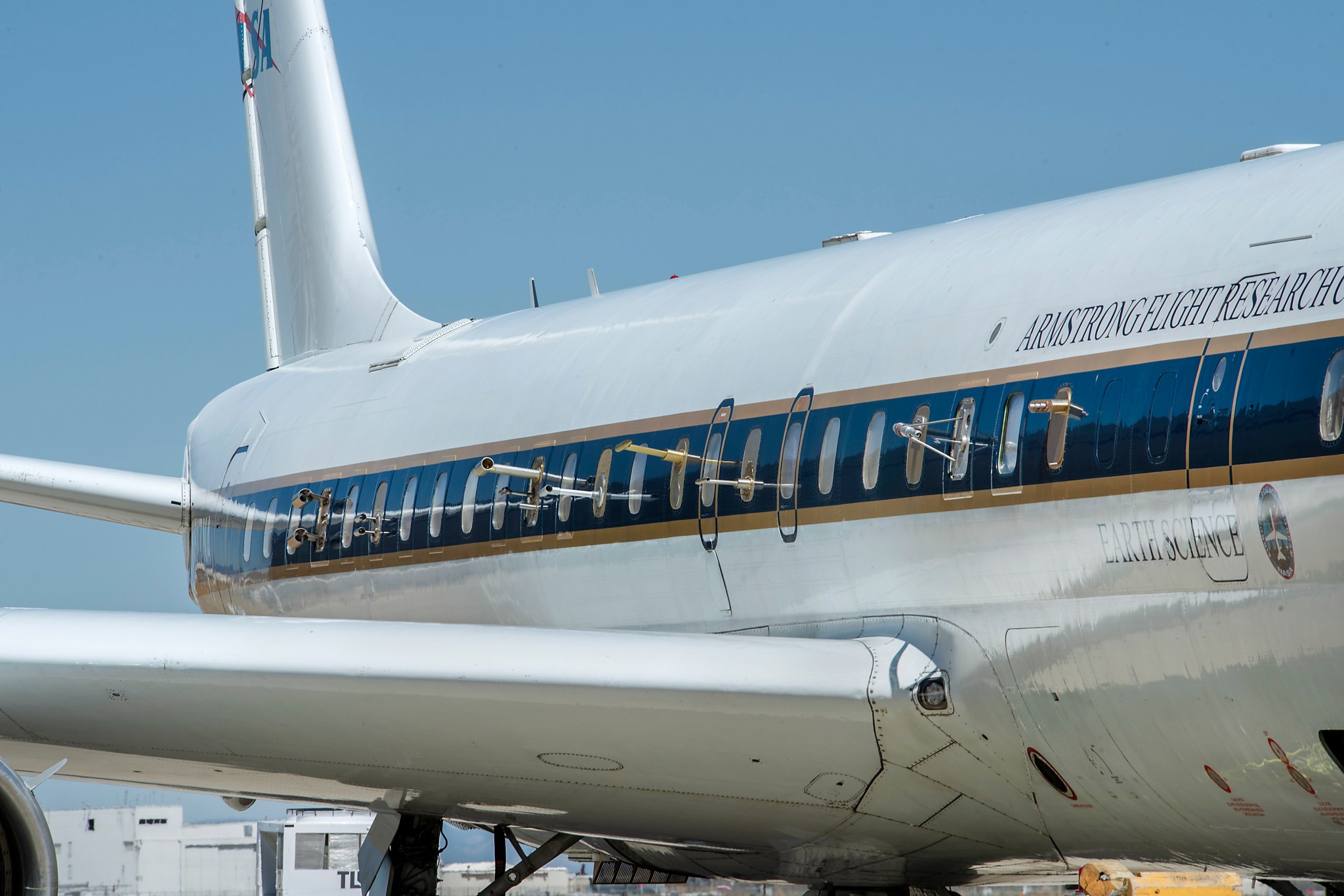 The side of NASA's DC-8 plane, with small gold and silver intake valves poking out of the side windows.