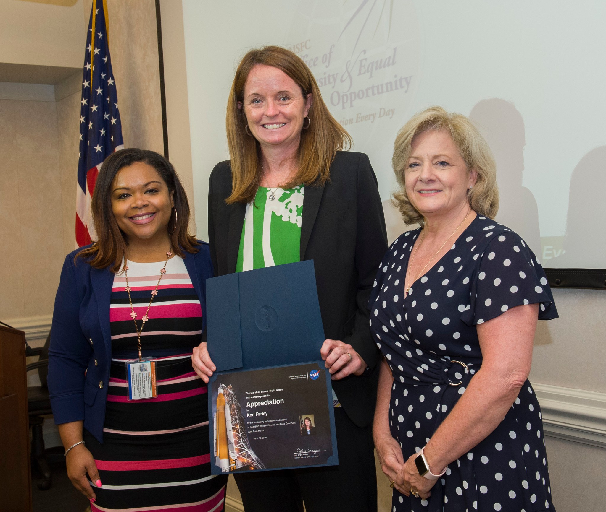 FBI Section Chief Keri Farley, center, receives a NASA certificate of appreciation from Jody Singer, right, and Denise Smithers.