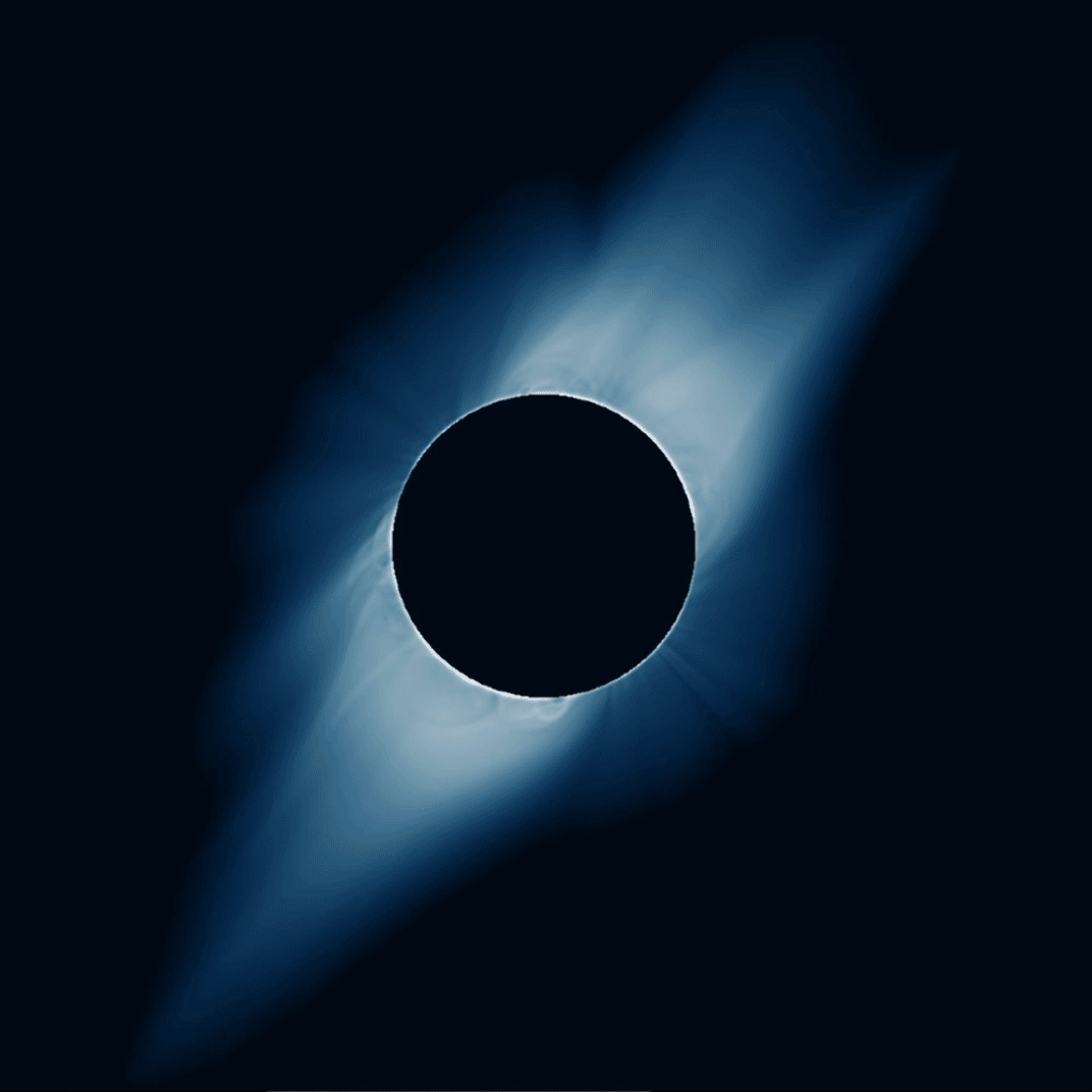 An animation alternating between a blue-hued graphic and a grayscale photo, both of a total solar eclipse on July 2, 2019. The blue-tinted graphic is a modeled image predicting how the Sun's corona would appear during the eclipse. In the simulation, the Moon looks like a black circle in the center, ringed in very light blue and with two delicate jets of pale blue light extending from the top right and bottom left of the Moon. The animation then fades to the grayscale photo, which looks nearly identical to the modeled image, but with more delicate detail visible in the Sun's corona. The dark gray disk of the Moon is ringed in white with delicate, wispy white rays of light extending out from it to the upper right and lower left.