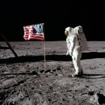 Astronaut Buzz Aldrin stands on the Moon facing a U.S. flag