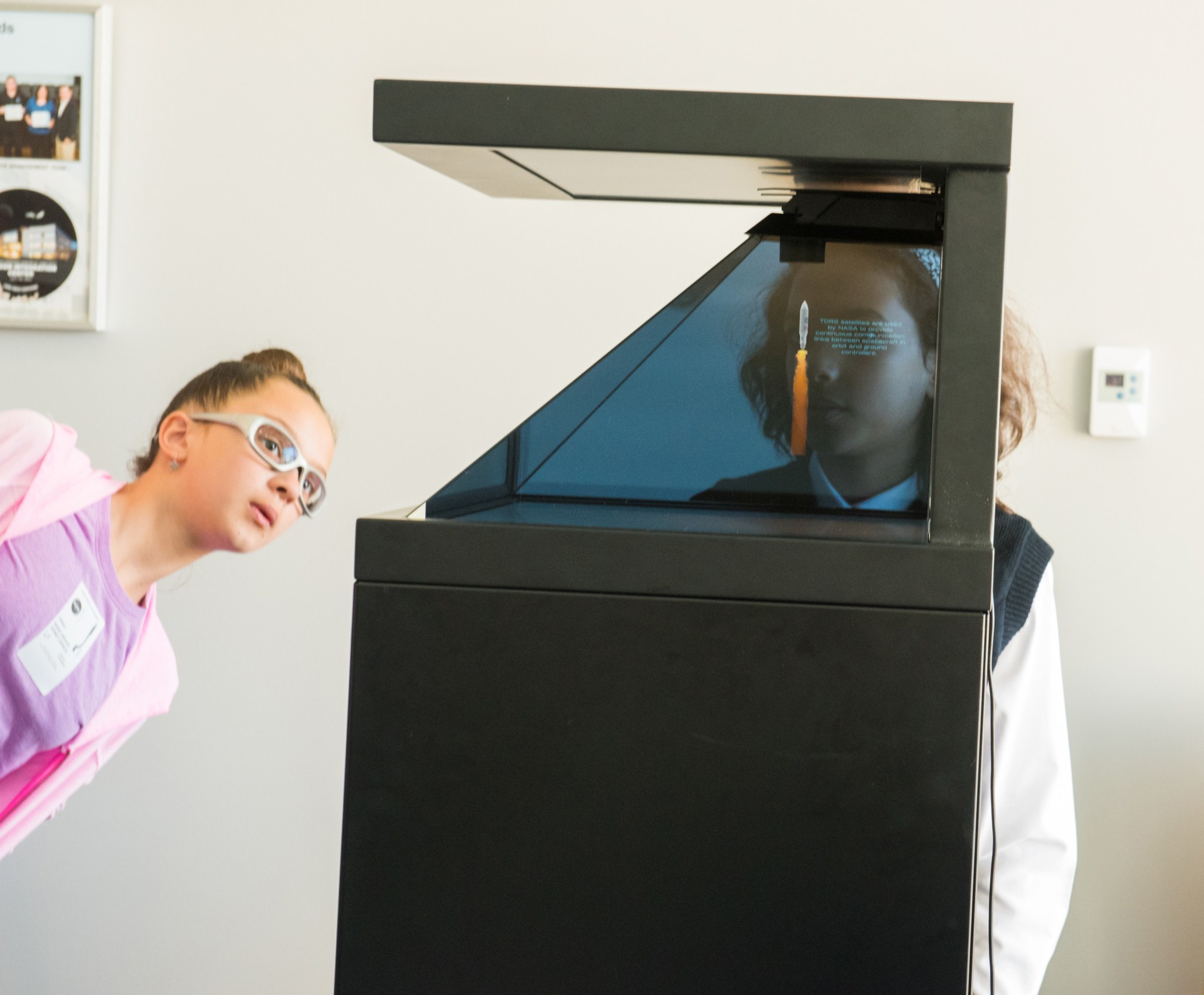 Students watching a holographic animation of a communications satellite launch at Girls in STEM 2018.