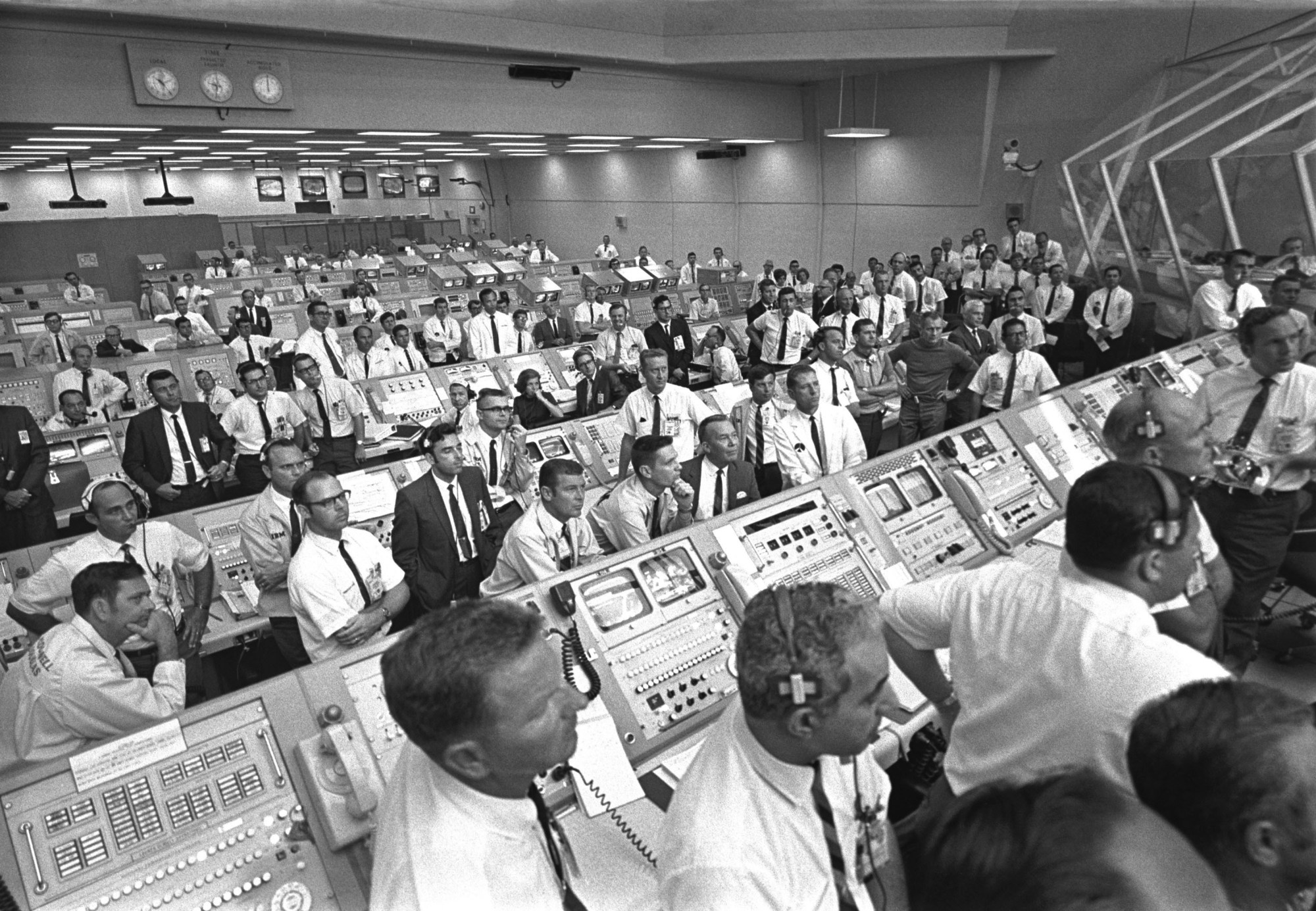 Photo show members of Kennedy Space Center team inside the Launch Control Center to watch Apollo 11 liftoff. JoAnn Morgan is seated to the left of center in third row.
