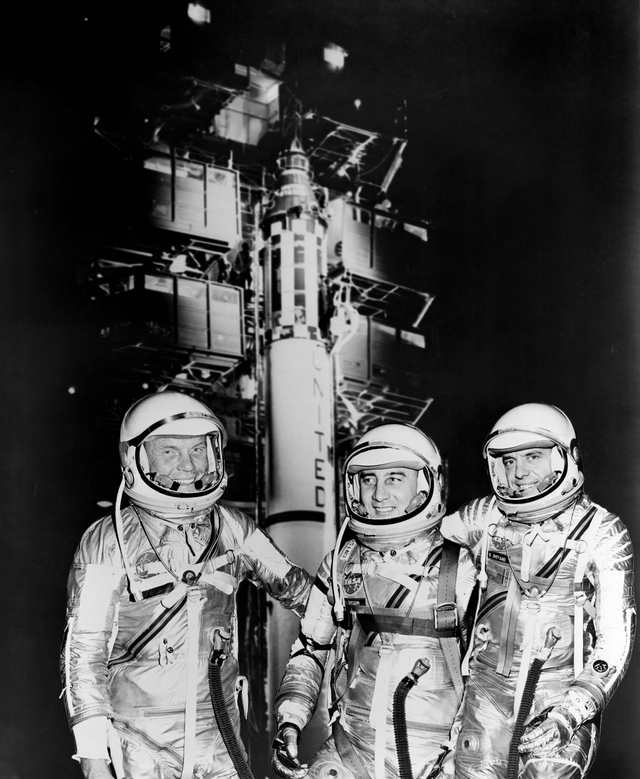 Astronauts standing in front of shuttle