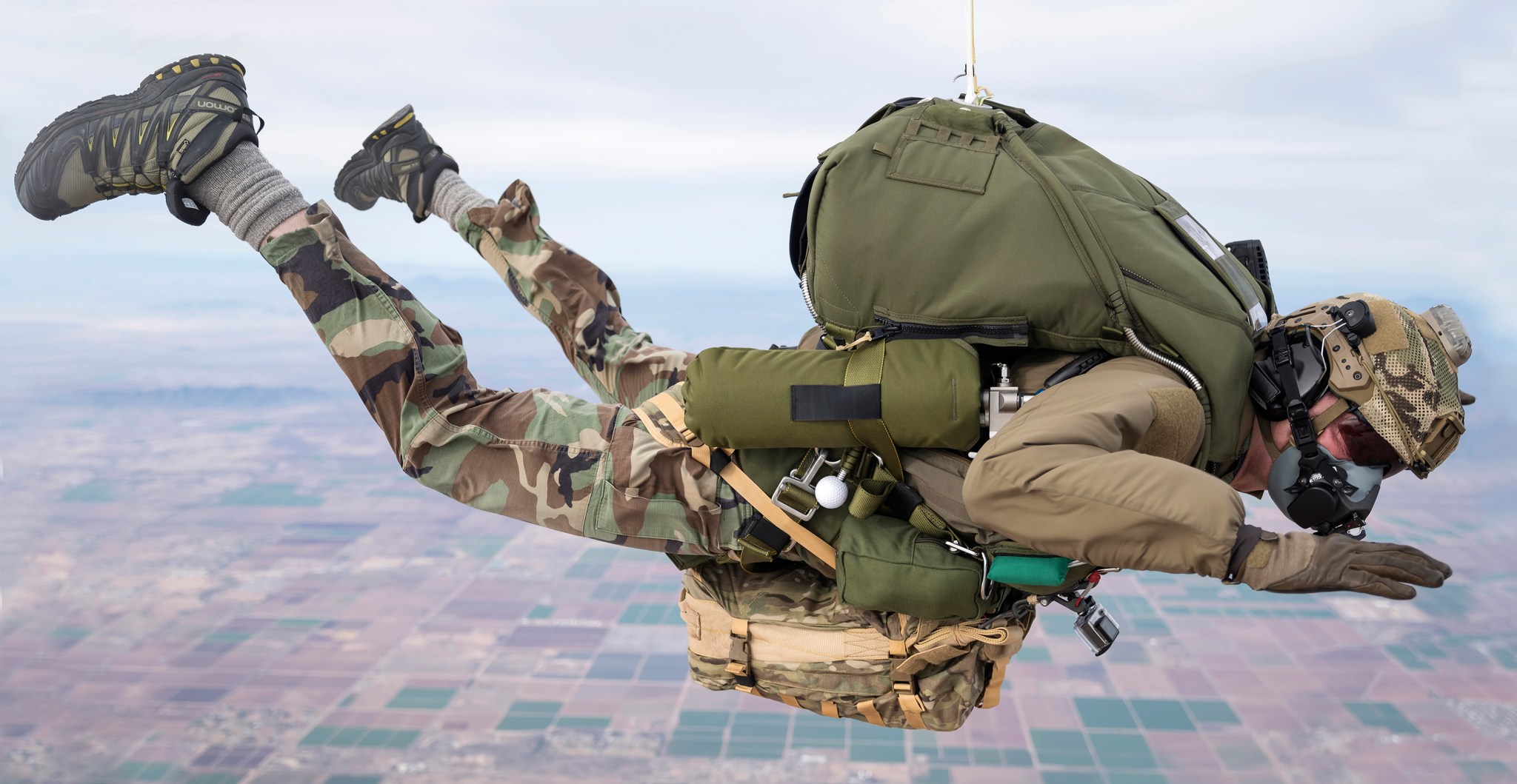 Parachuter in the air wearing a gas regulator over their face.