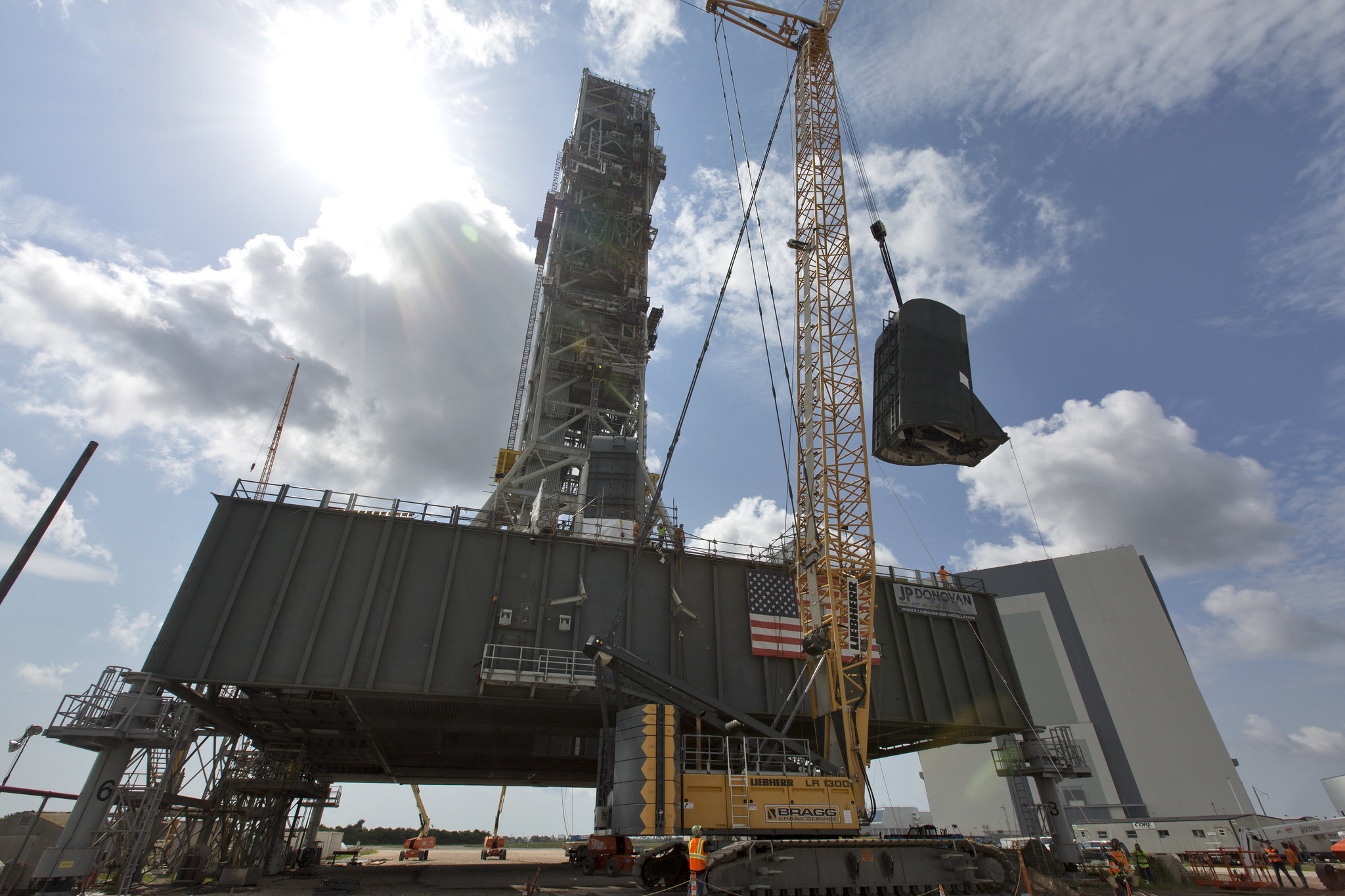 A crane lifts the second of two tail service mast umbilicals up for installation on the 0-level deck of the mobile launcher on July 27, 2018, at NASA's Kennedy Space Center in Florida.
