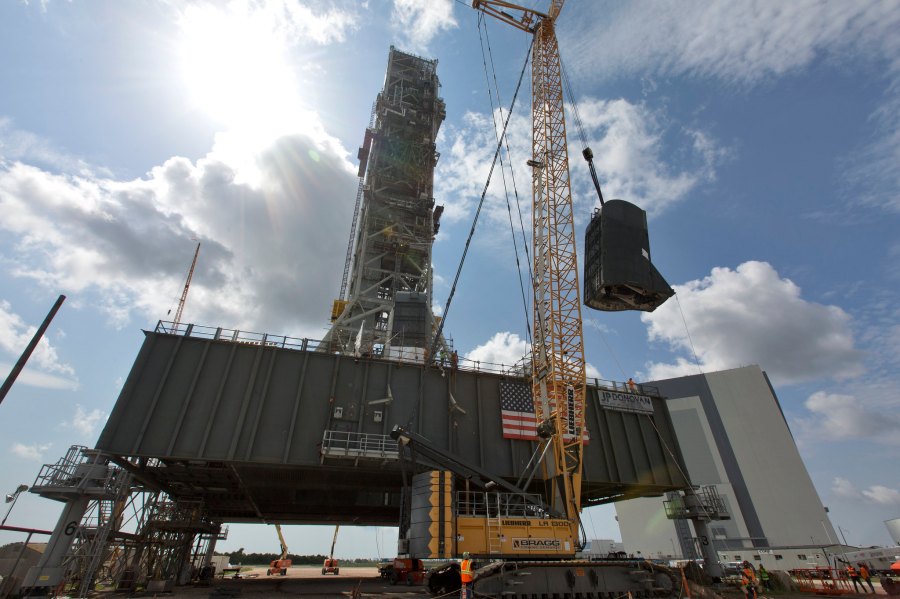 A crane lifts the second of two tail service mast umbilicals up for installation on the 0-level deck of the mobile launcher on July 27, 2018, at NASA's Kennedy Space Center in Florida.