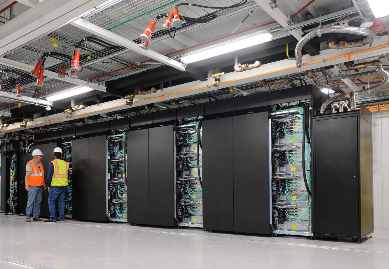 Workers inspect hardware at the Modular Supercomuting facility.