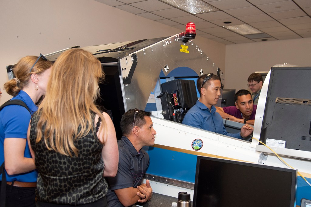 NASA's 2017 astronaut candidates practice flying in an X-59 QueSST simulator at AFRC.