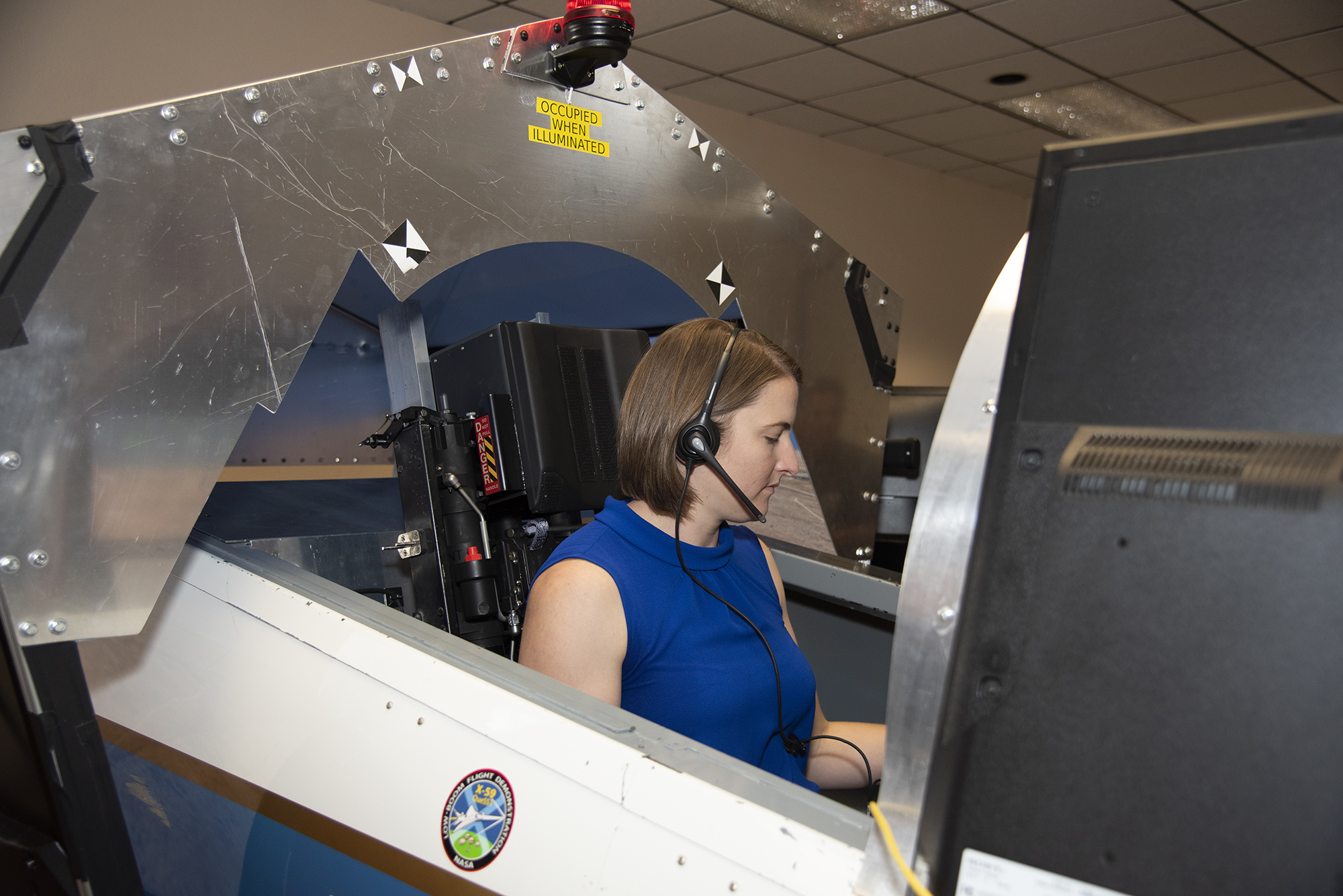NASA's 2017 astronaut candidate Kayla Barron practices flying in an X-59 QueSST simulator at Armstrong Flight Research Center,