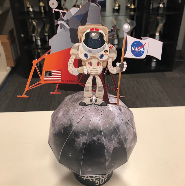 Paper model of the Moon with an astronaut and lander on top