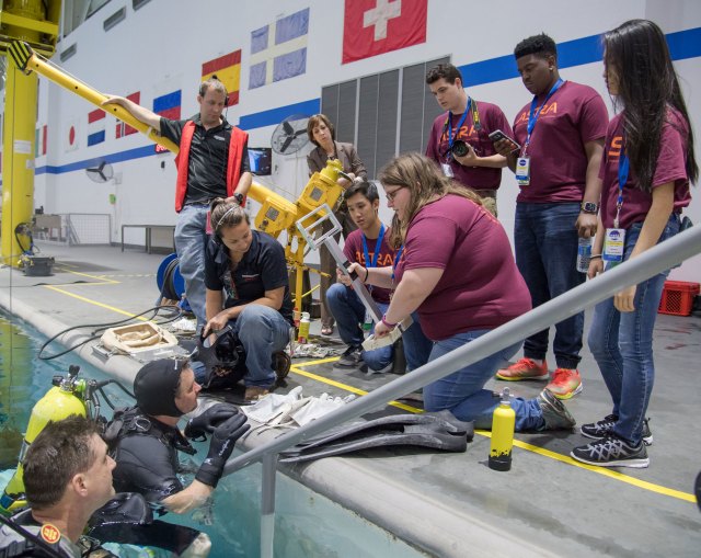 Students at the Neutral Buoyancy Laboratory with divers testing tool prototypes