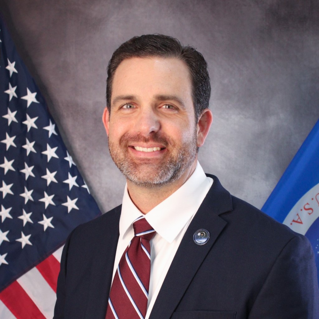 Official photo of Jeremy Parsons with American flag in the background