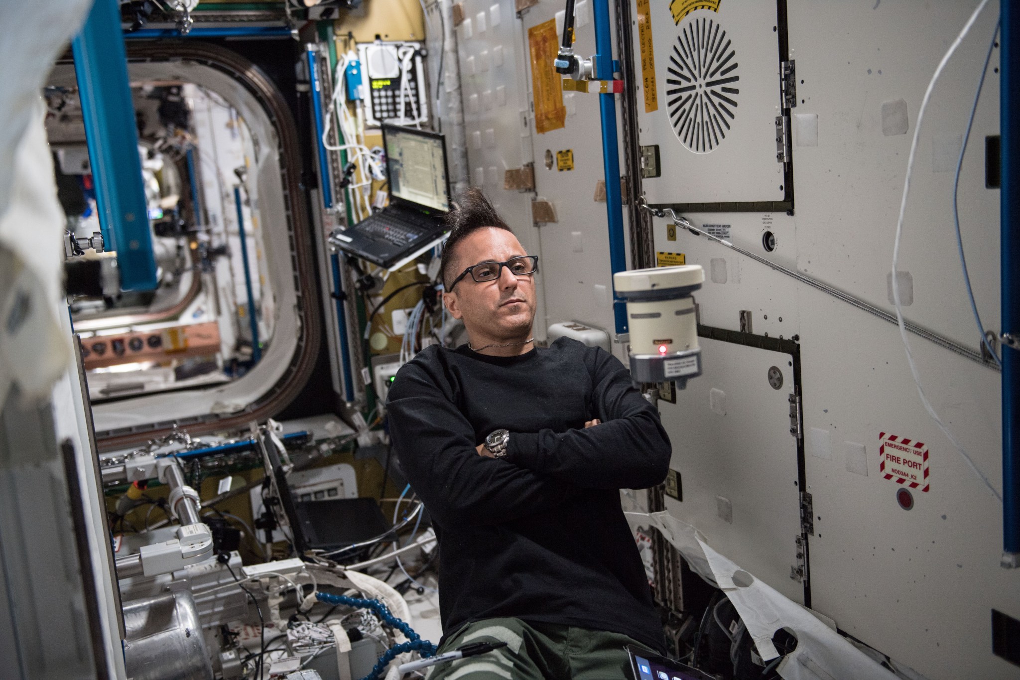 astronaut Joe Acaba using an air sampling device inside the space station
