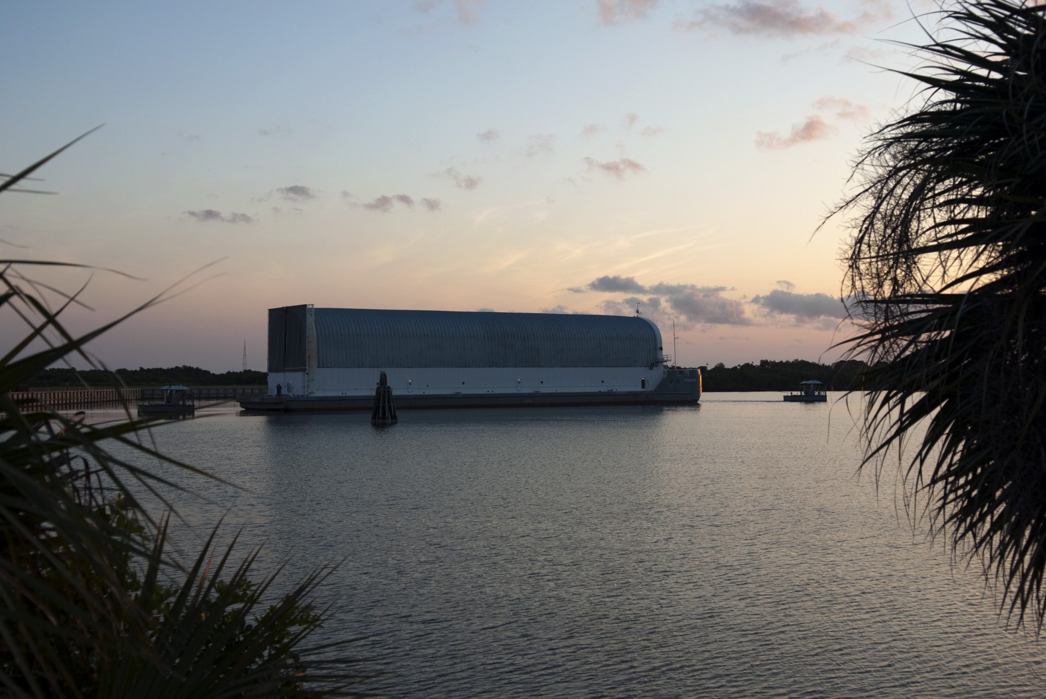 Tugboats tow the Pegasus Barge away from the dock in the Turn Basin in Kennedy Space Center's Launch Complex 39 area.