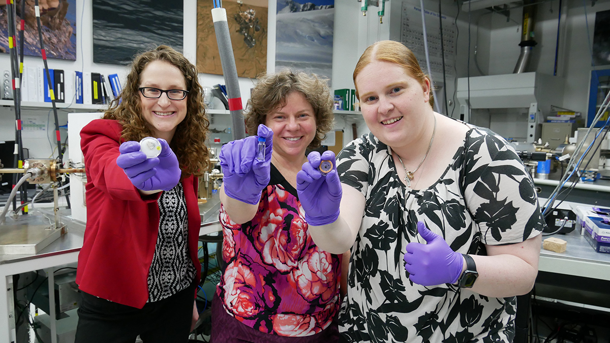 Three women holding tech