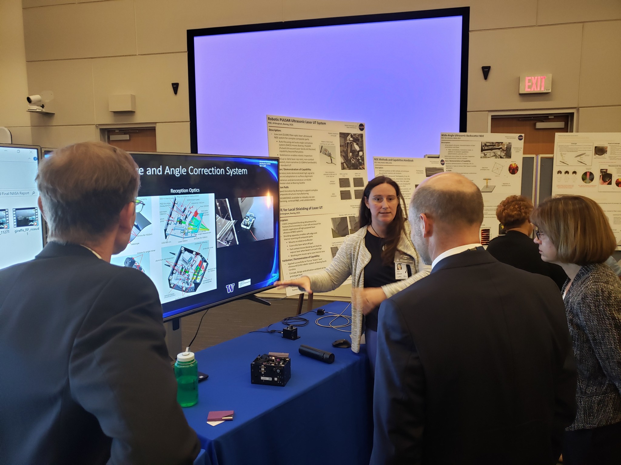 A female NASA researcher explaining composites to a group of people.