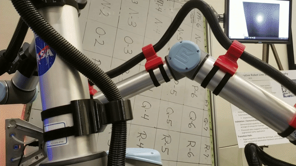 Animated gif of a robotic arm from a video inspecting a composite material.