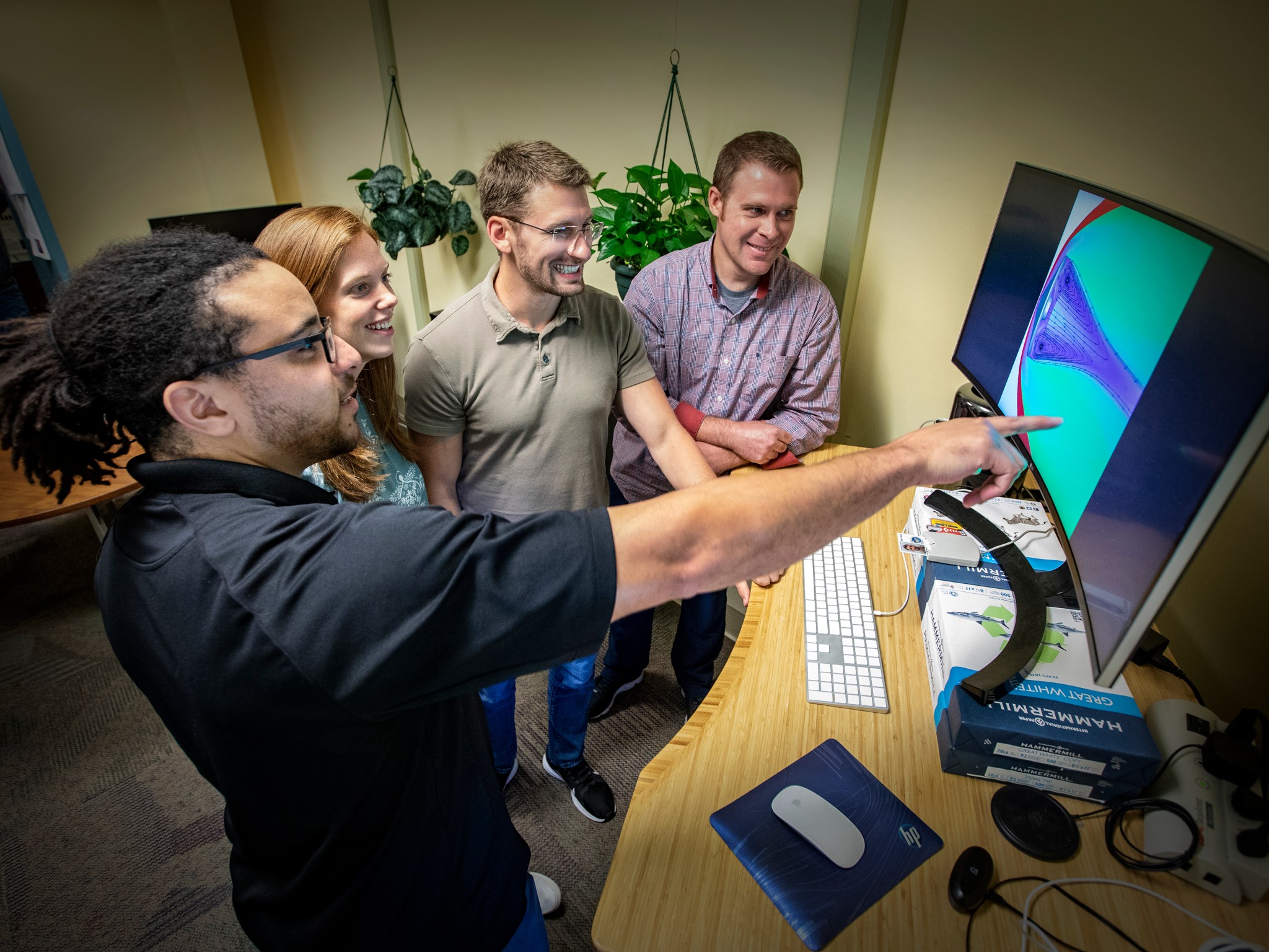 The team examines a computational fluid dynamics computer simulation.