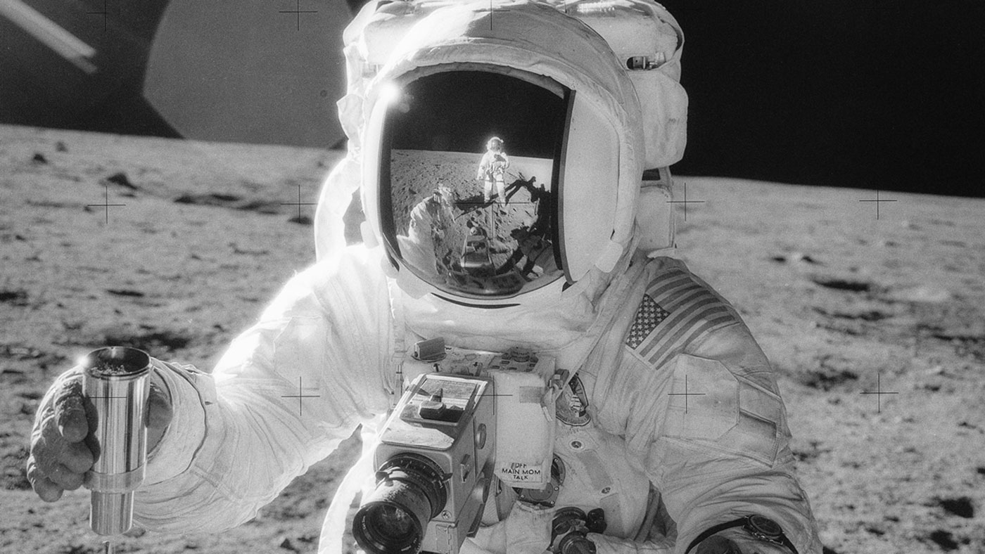 Apollo 12 lunar module pilot Alan Bean holds a container of lunar soil