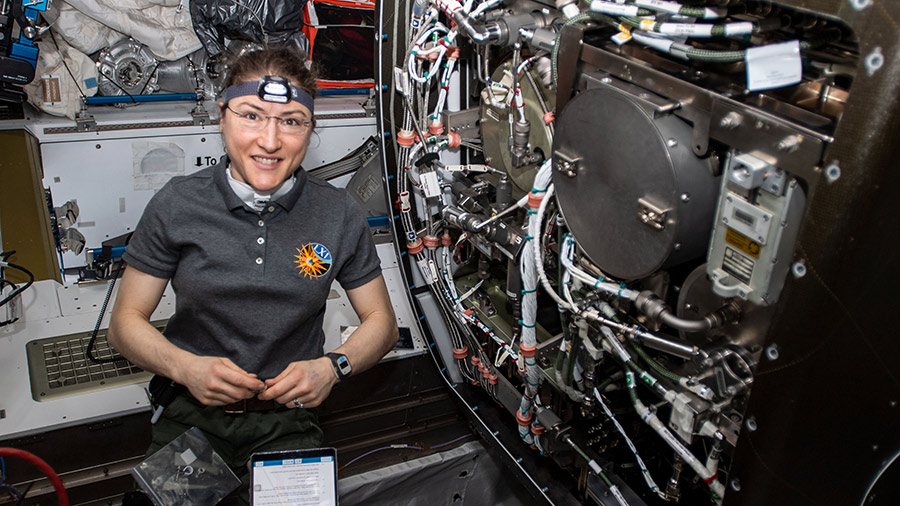 Astronaut Christina Koch works on orbital plumbing tasks