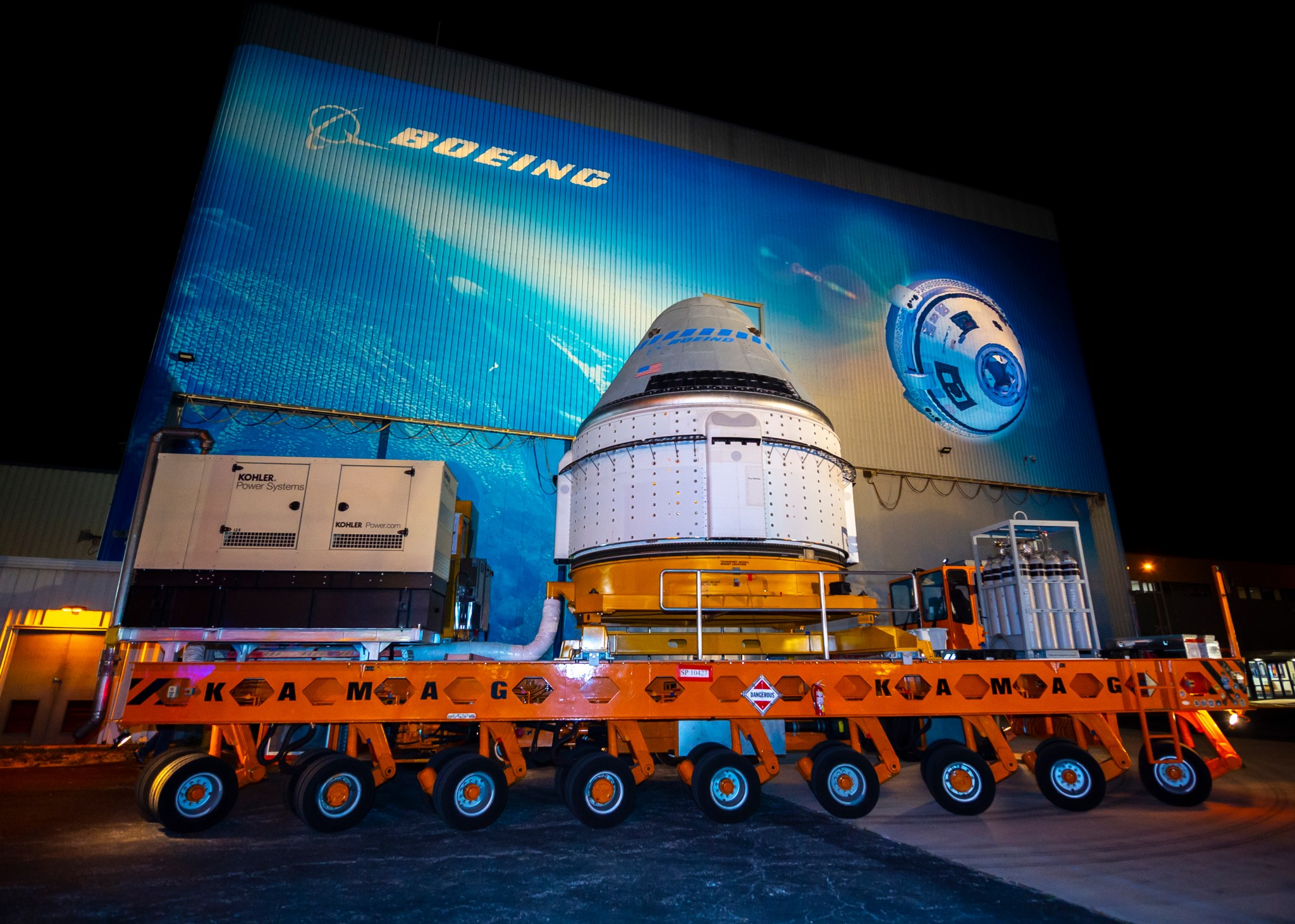 The Boeing CST-100 Starliner spacecraft rolls out from the company’s Commercial Crew and Cargo Processing Facility.