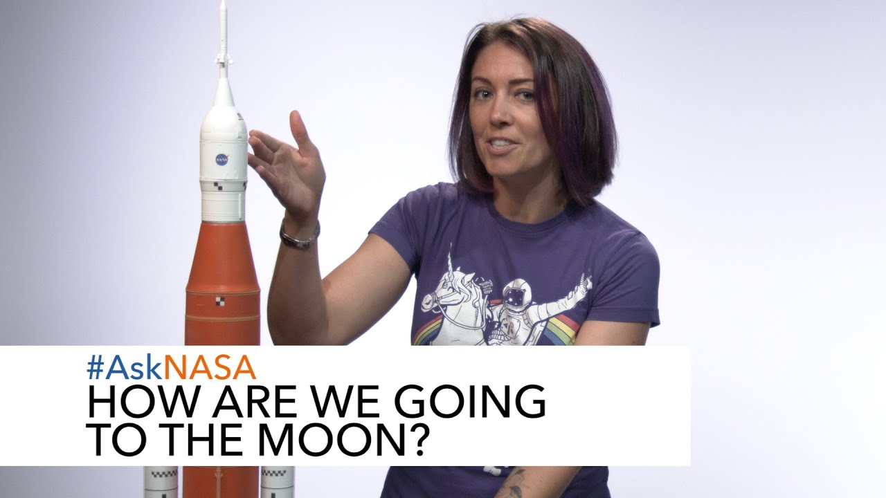 NASA Spacesuit Engineer Lindsay Aitchison points to a model of the SLS rocket with the words “#AskNASA: How Are We Going to the 