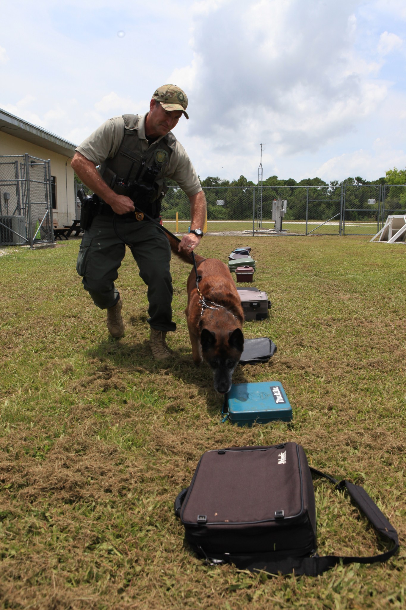K-9 Officer Scott O’Rourke watches as K-9 LJ works his way through a row of bags and containers.
