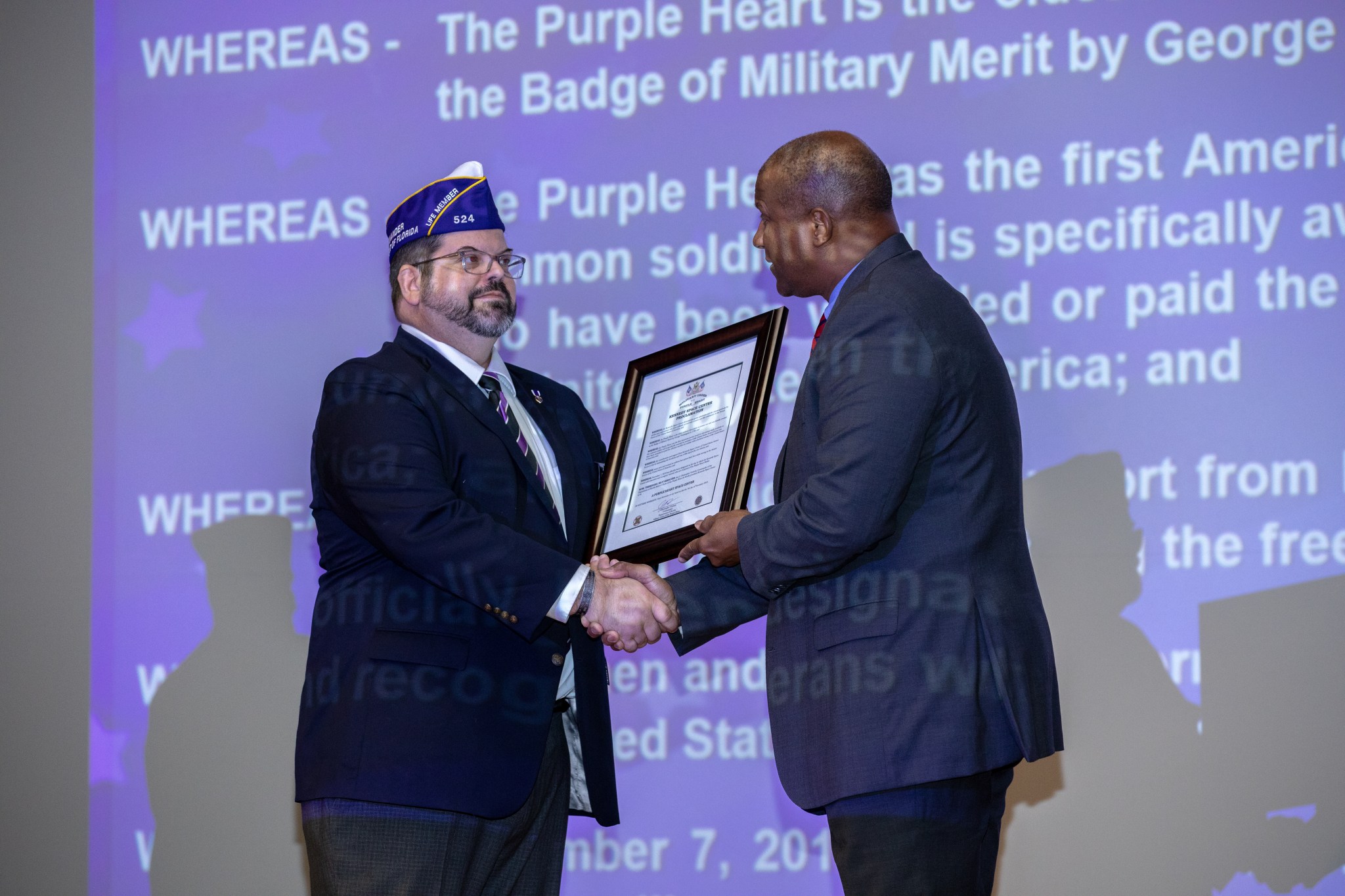 Christopher Vedvick, left, presents Kennedy Space Center’s Associate Director, Technical, Kelvin Manning with a proclamation.