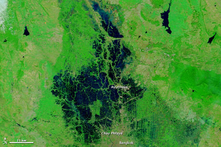 A satellite image of the area around Ayutthaya, Thailand in 2011. The area is mostly bright green, with the city labeled in white. To the left of the city, dark blue water is extending to the upper and lower edges of the image, and even covering much of the area labeled part of the city.