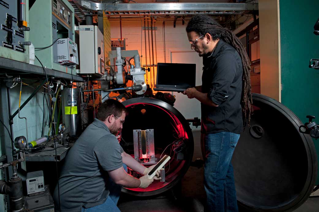 Flammability engineers evaluating posttest flammability samples