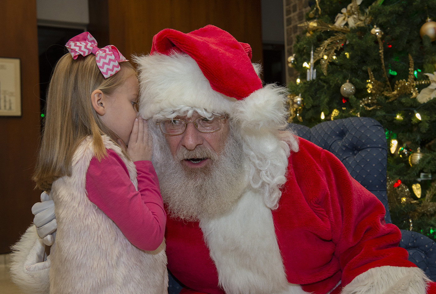 At the Marshall holiday tree lighting Dec. 9, Bentley Deemer bends the ear of Santa Claus.