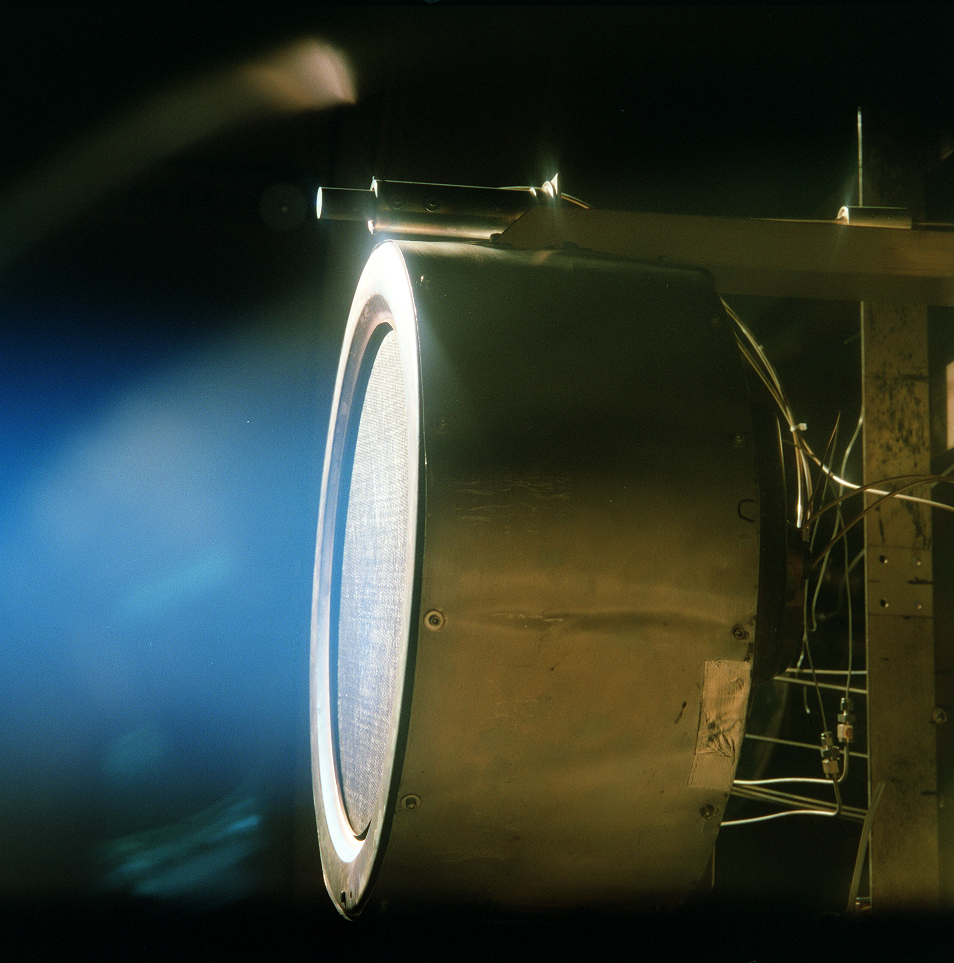 A xenon ion engine prototype, photographed through a port of the vacuum chamber