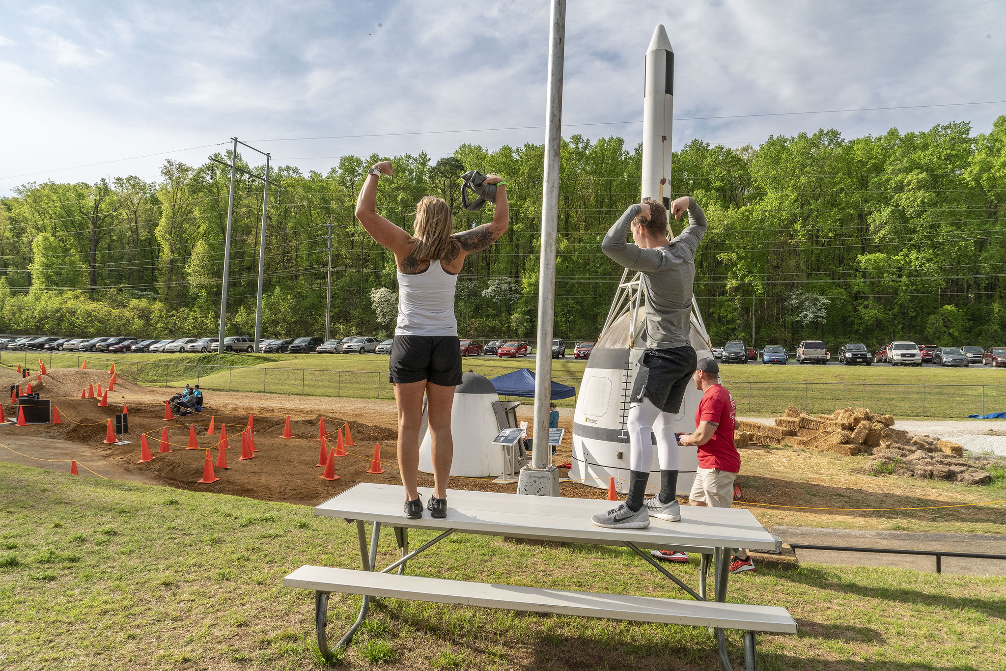 2 people standing on a picnic table