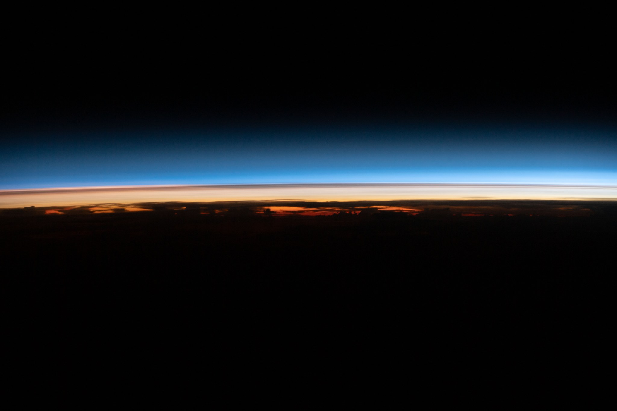 image of a thin blue line over a thin orange line resembling Earth's limb and stratosphere