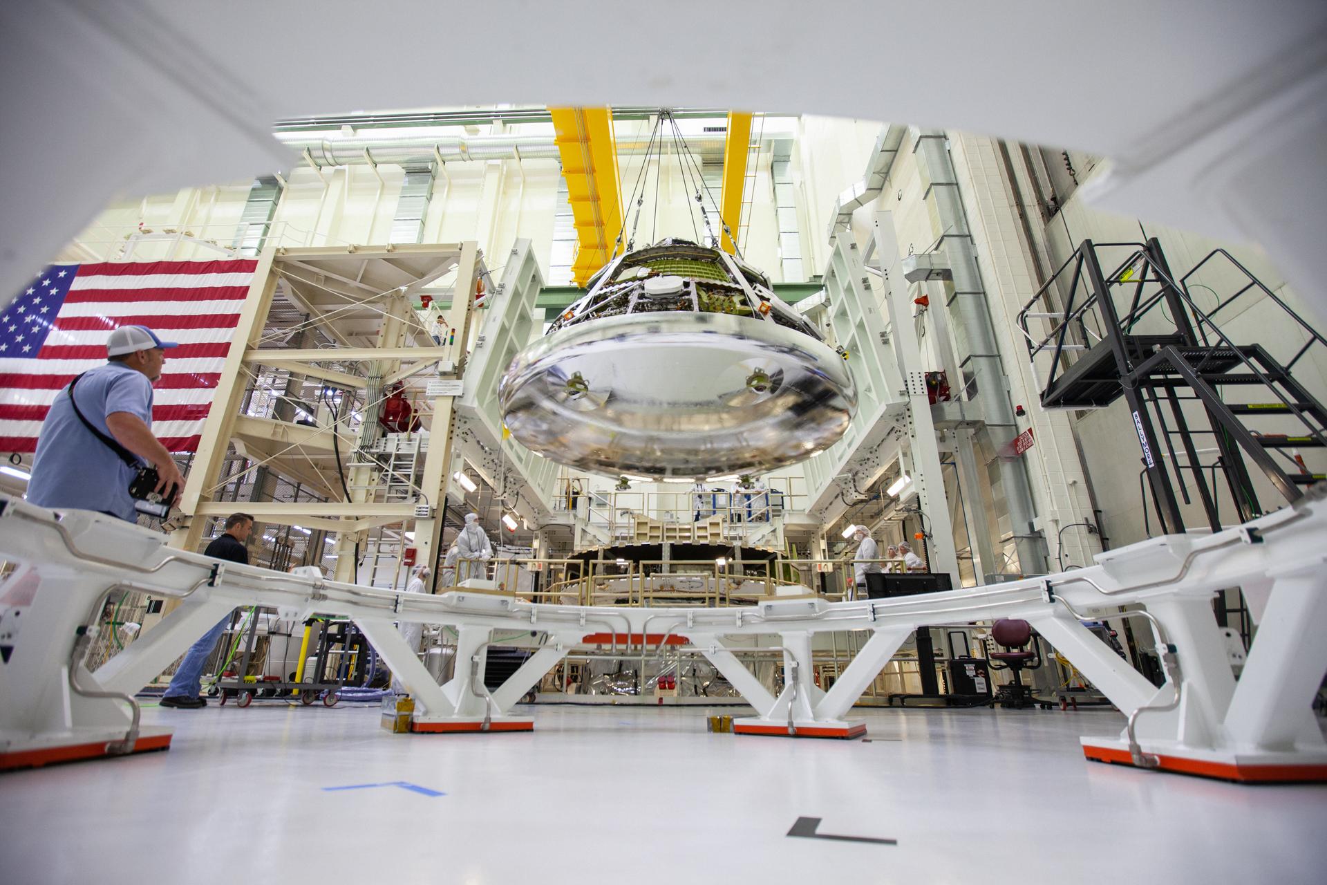 The Orion crew module for Artemis I is lifted by crane in the O&C high bay at Kennedy Space Center in Florida. 