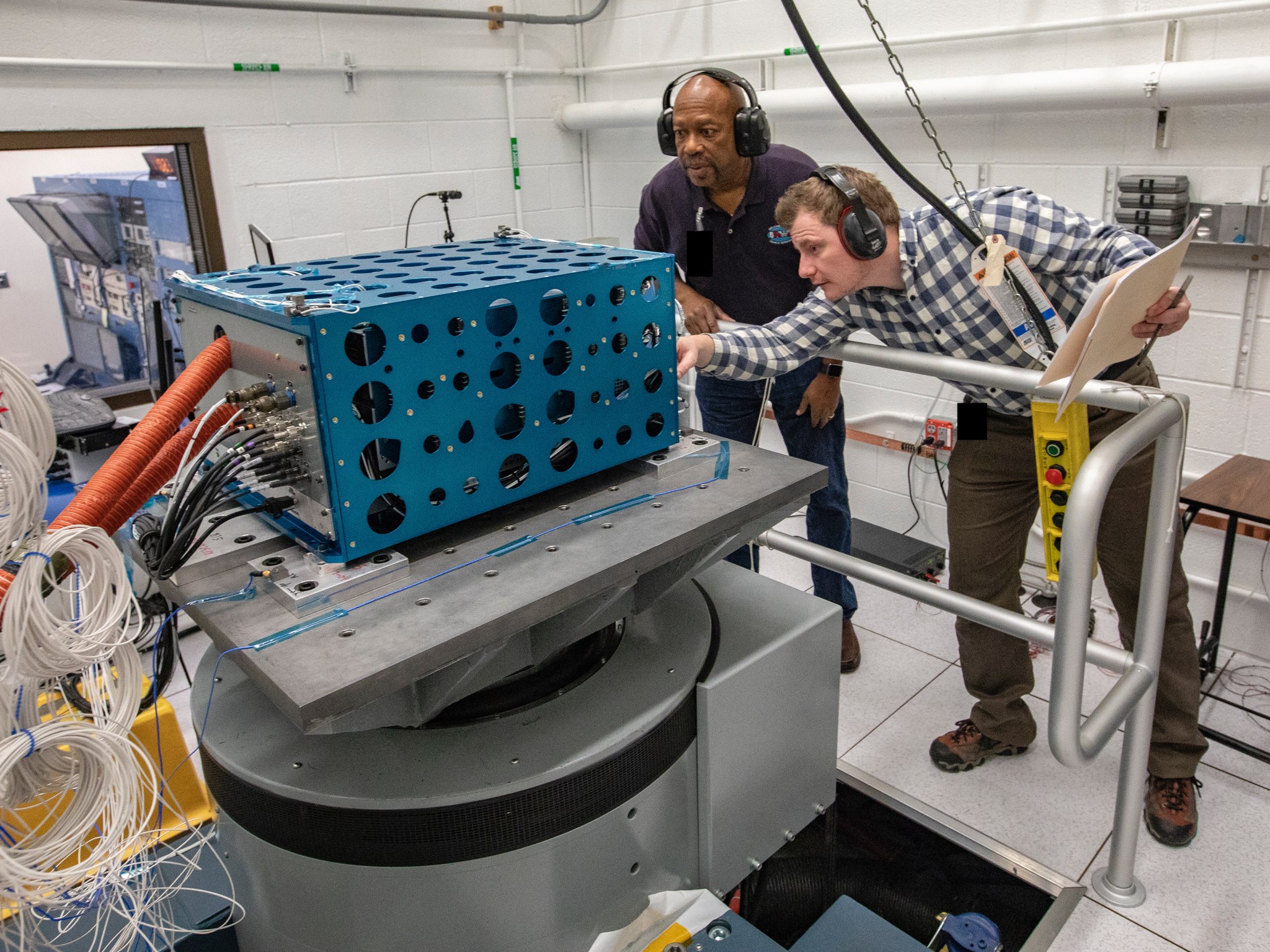 Two NASA employees monitoring low boom display hardware.