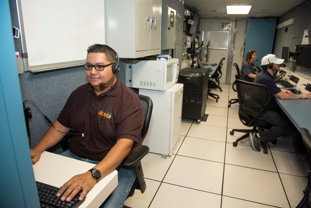 Technicians are at stations in the Mobile Operations Facility 5 at AFRC