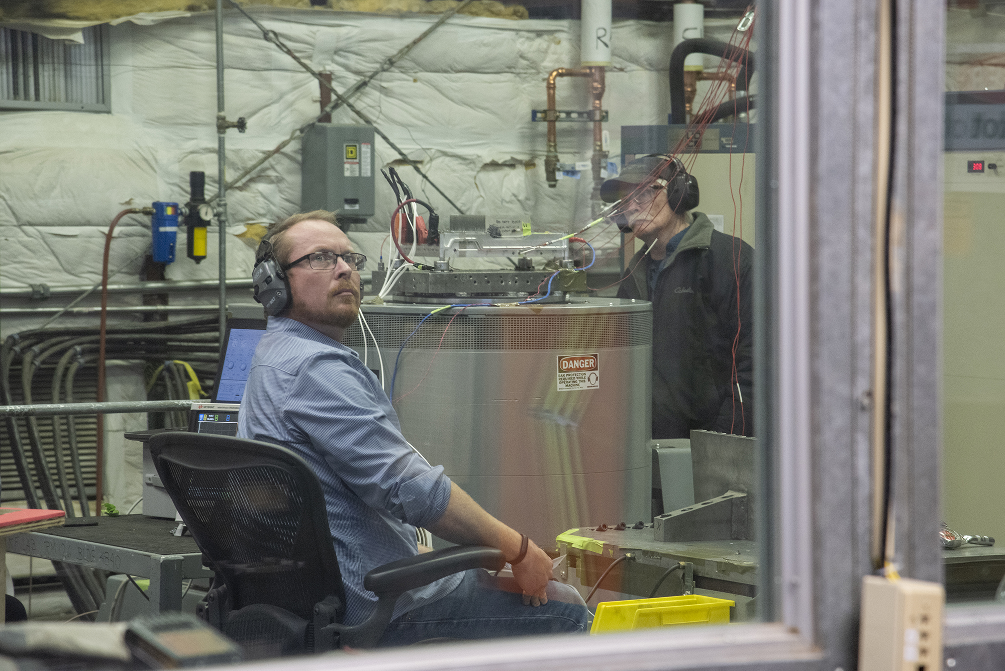 Engineers monitor data during vibration testing of a cruise motor controller for the X-57 Maxwell.