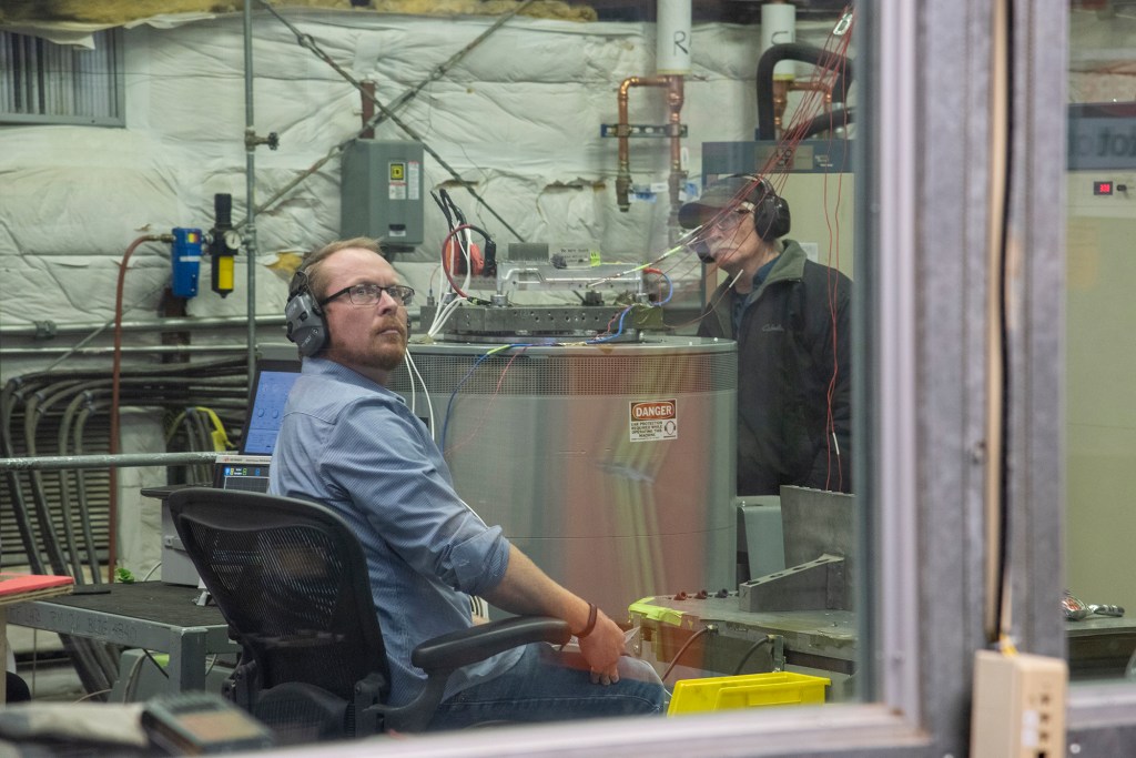 Engineers monitor data during vibration testing of a cruise motor controller for the X-57 Maxwell.