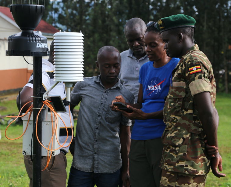 people looking at a rain gauge