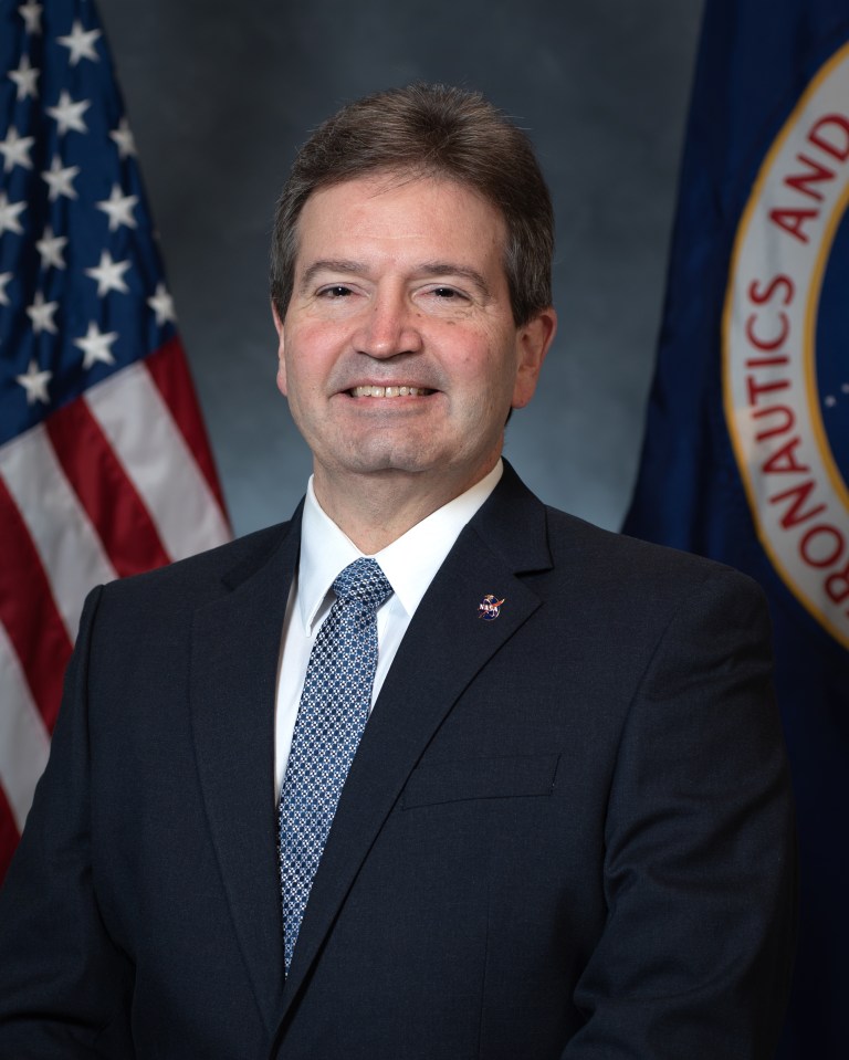 Portrait of Gary Garbinski with U.S. and NASA Flags in background.