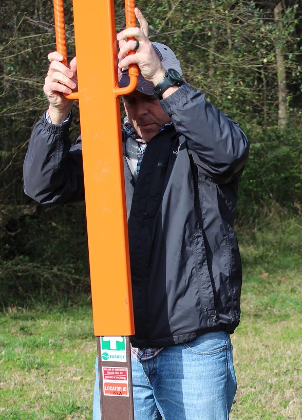 Man putting sign post into the ground