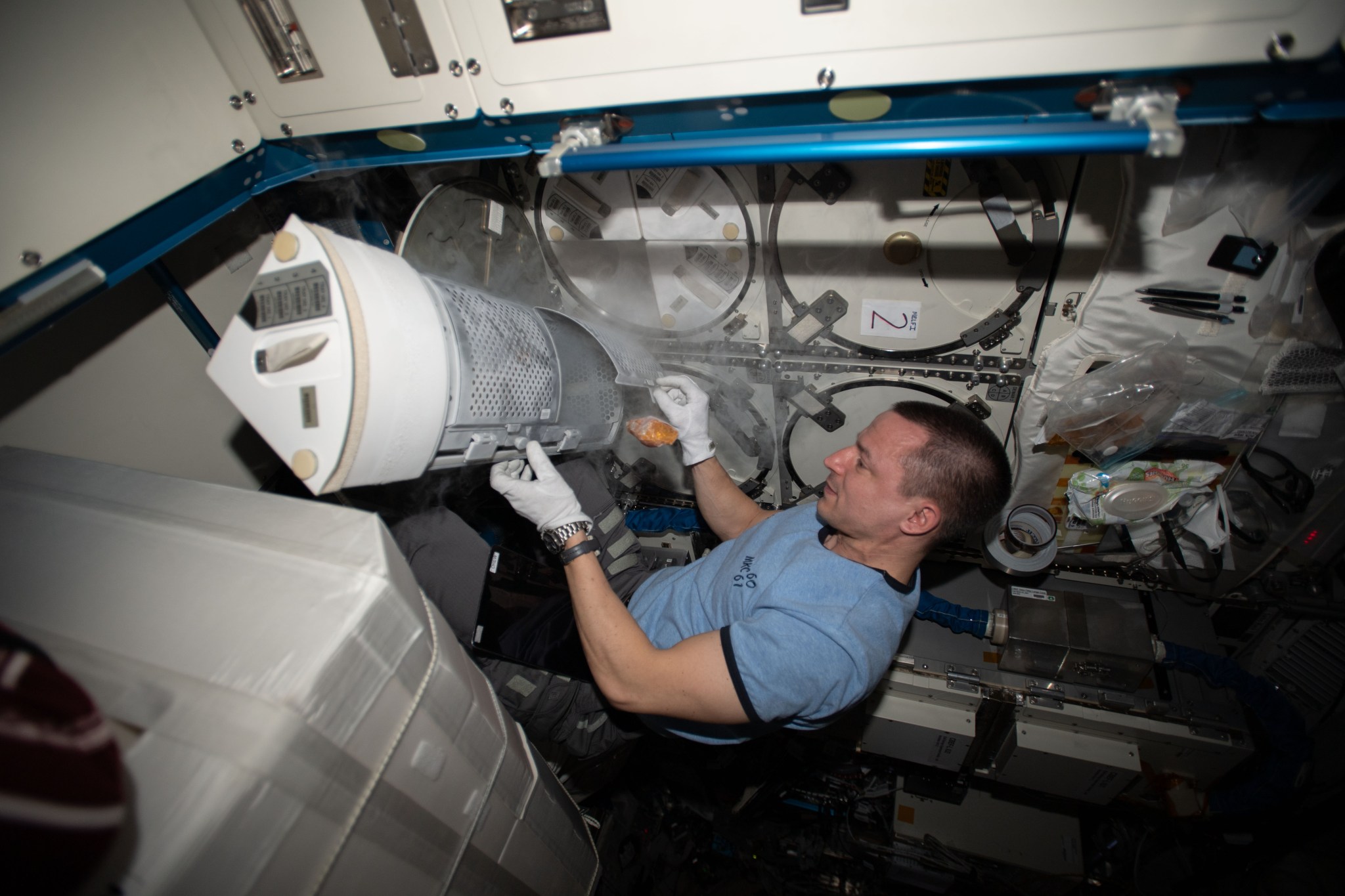 NASA astronaut Andrew Morgan places samples in cold stowage.