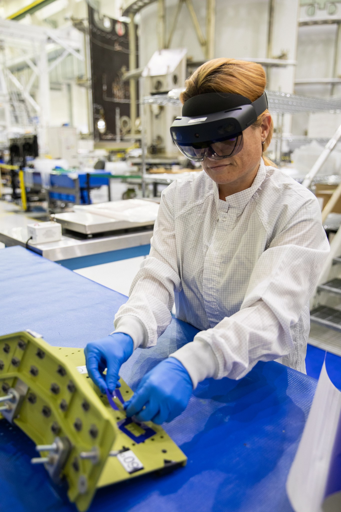 A technician wears augmented reality goggles to work on crew module hardware at NASA's Kennedy Space Center in Florida.