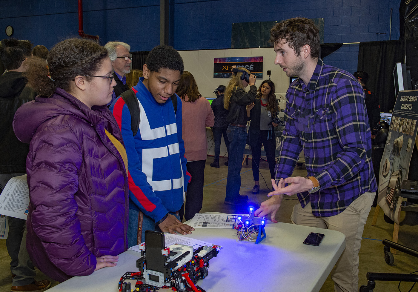 Alexander Summers, right, an engineer at NASA’s Marshall Space Flight Center, talks with Amber George, left, and Steven Hughes.