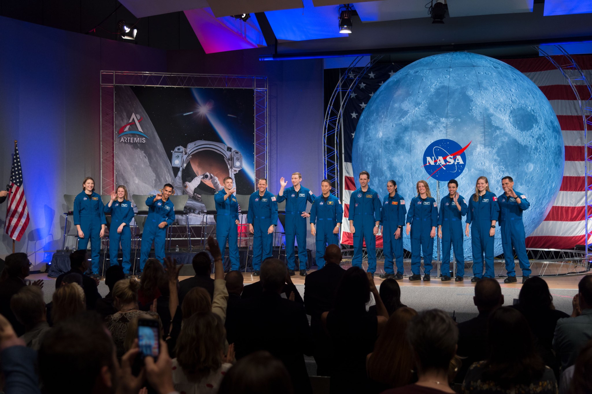 NASA's new class of astronauts appear on stage during their graduation ceremony at the agency’s Johnson Space Center in Houston
