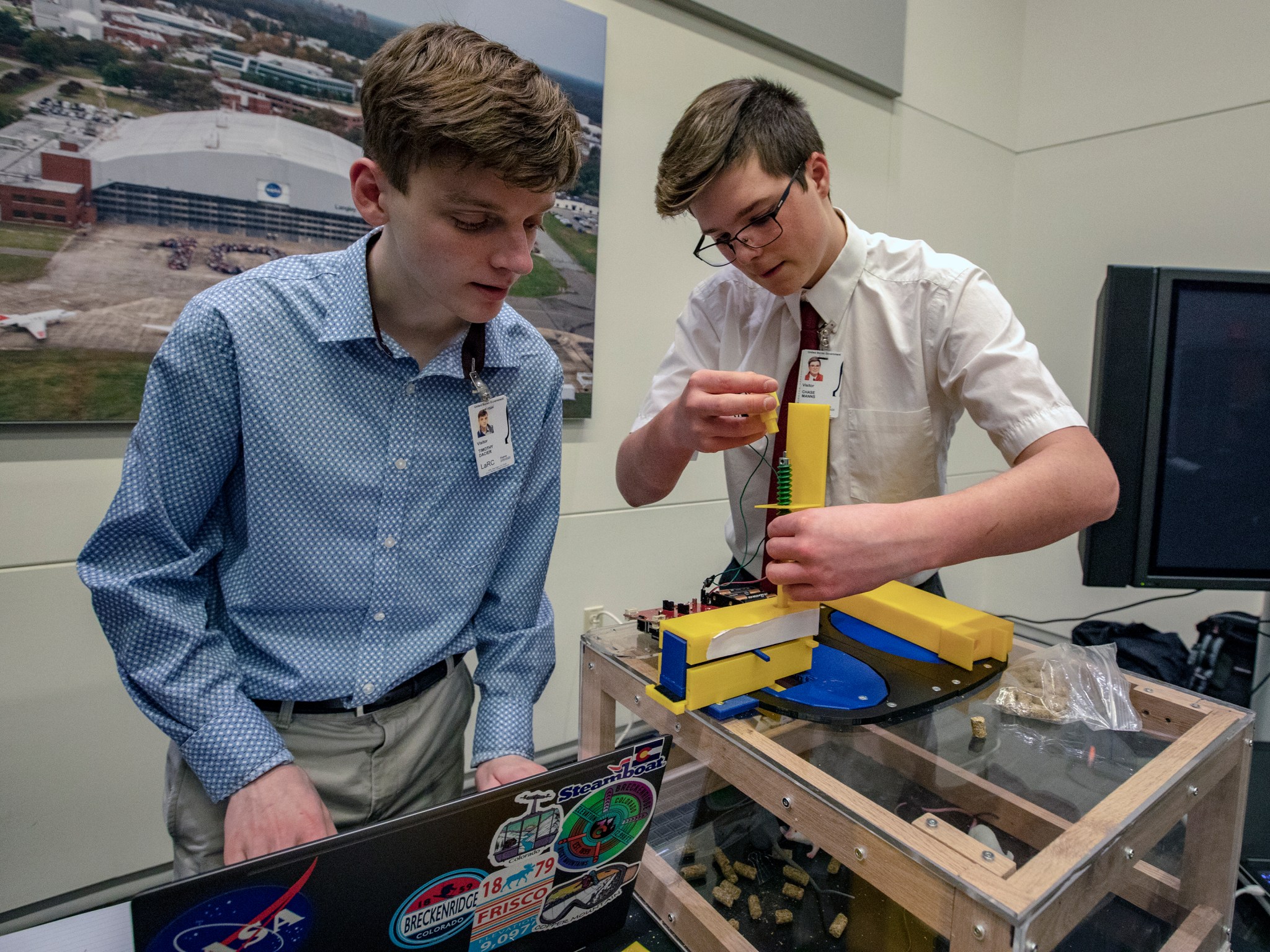 Warhill High School team members Timothy Dacier, left, and Chase Manns work on their zero-G mouse feeder.
