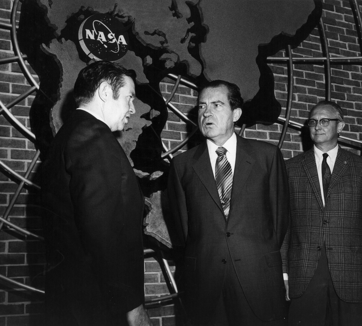 Clark greets Nixon in front of the NASA logo
