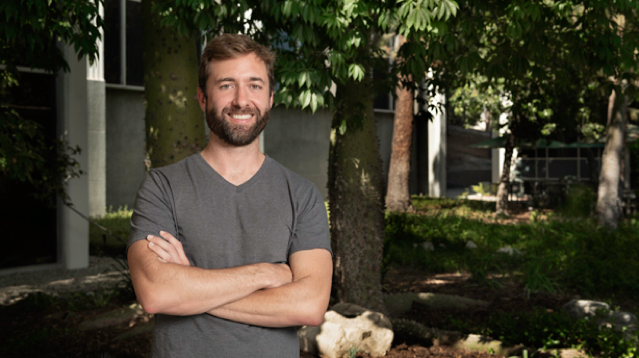 Dr. JT Reager stands under a tree outside.