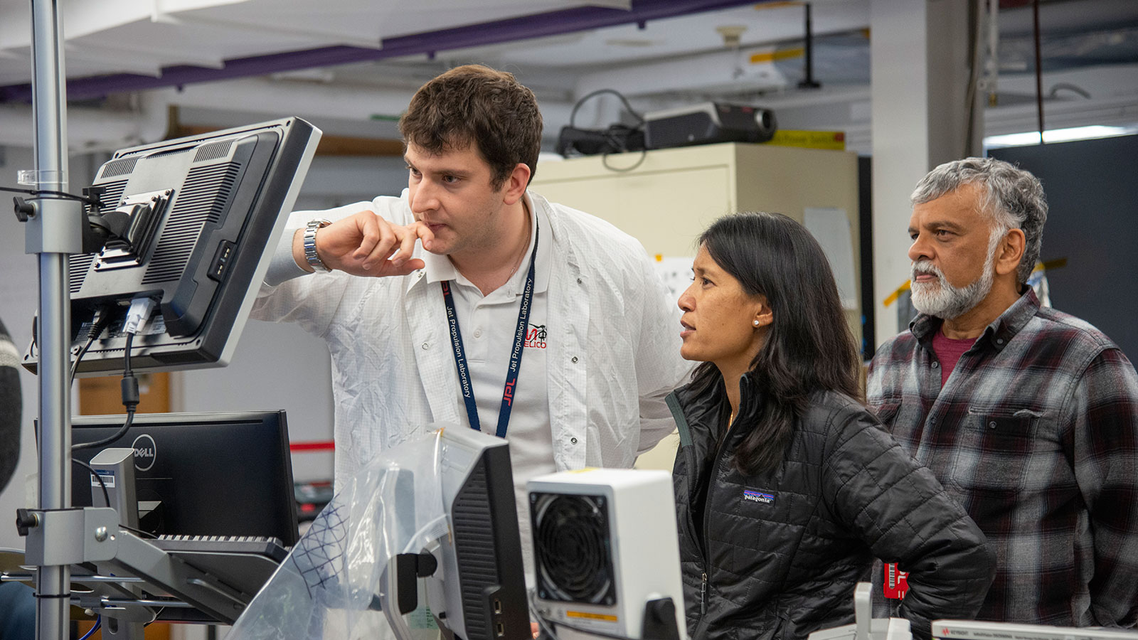 (l-r) Teddy Tzanetos, MiMi Aung and Bob Balaram observe a flight test